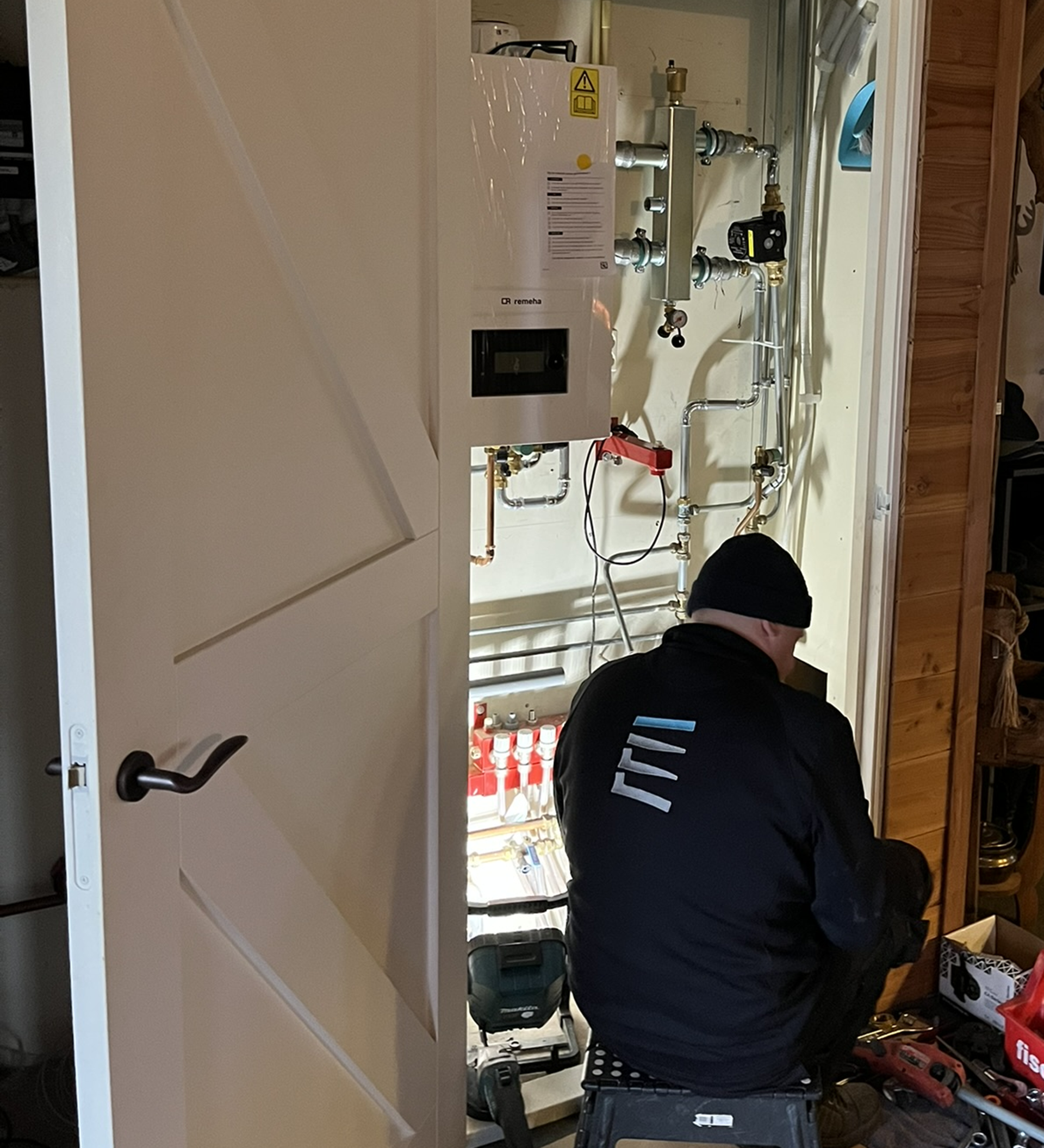 Monteur van Calor Clima installeert een warmtepomp bij een particuliere woning.